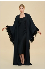 Detail of elegant black satin robe with luxurious feather cuffs and silk slip dress set
