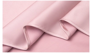 Dettaglio del tessuto in chiffon di perle rosa chiaro con consistenza setosa e pieghe