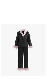 Détail d'un pyjama en satin noir avec plumes roses aux poignets et à l'ourlet