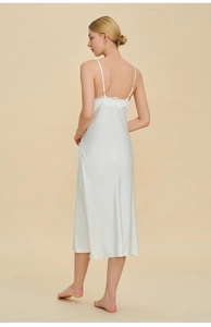 Elegante sottoveste in raso bianco con pizzo, mostra la schiena scoperta e il drappeggio