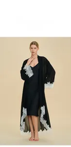 Detail view of black silk satin robe and slip dress set with white lace trim on sleeves