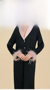 Détail d'un pyjama en satin de luxe avec poignets en plumes et col à revers rose chic