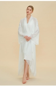 Detailed embroidery on white silk bridal robe with delicate lace sleeves and hemline