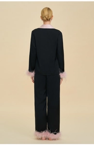 Vue arrière du pyjama de luxe en satin noir avec des plumes roses élégantes aux poignets