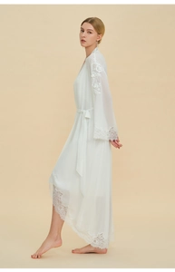 Close-up of elegant white chiffon robe with eyelash lace trim and floral embroidery