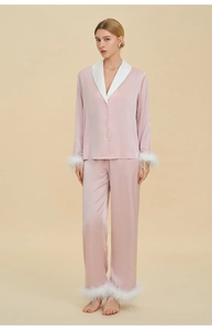 Pyjama de luxe en satin rose avec d'élégantes plumes blanches aux poignets et aux chevilles