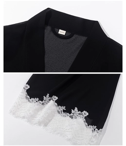 Detail of black chiffon robe with one size label and white floral eyelash lace trim