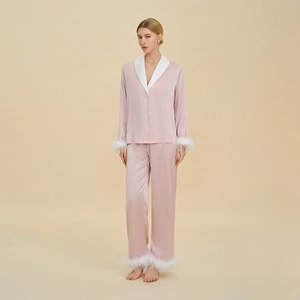 Pyjama rose en soie pour femme avec plumes blanches aux poignets et aux chevilles
