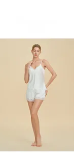 Détails d'un pyjama blanc en soie avec dentelle sur le caraco et le short