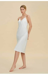 Detail of white satin slip dress featuring a deep V-neck and delicate spaghetti straps