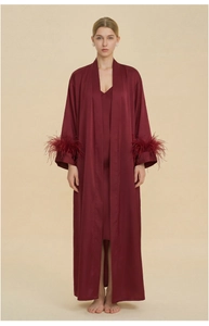 Detail view of dark red satin robe with luxurious feather trim on long sleeves
