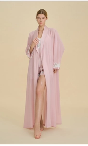 Detail view of pink three-piece pajama set featuring delicate white lace trim on sleeves