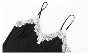 Détail du col en V avec dentelle florale blanche sur nuisette noire satinée