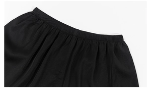 Détail de la taille élastique plissée sur un short de pyjama noir en satin