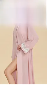 Detail view of pink satin robe sleeve featuring delicate white lace trim and silky fabric