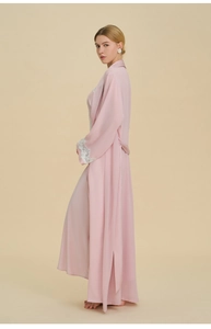 Dettaglio della vestaglia in raso rosa con pizzo bianco elegante e trama setosa