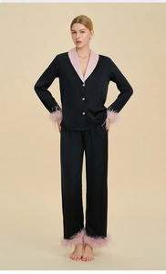 Detail of luxury black silk pajamas featuring pink detachable feather trim on cuffs