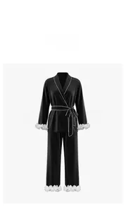 Detail of black satin pajama set with contrast white piping and floral cuffs
