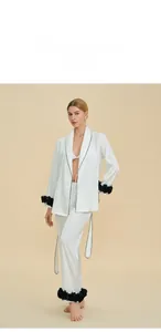 Detail showing the white satin pajama sleeve with black floral trim and elegant contrast piping