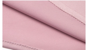Macro shot of smooth pink pajama fabric showing precise stitching and silky texture detail