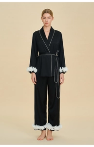 Detail of satin pajama cuffs with white 3D floral ruffles and contrast piping trim