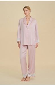 Detailed close-up of premium pink satin pajama set with intricate white lace trim on cuffs