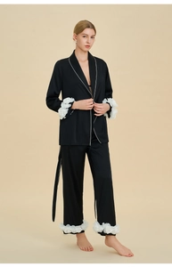 Detail of black silk pajamas featuring 3D white floral appliques on cuffs and hems