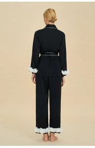 Rear view of elegant black satin pajama set featuring white 3D floral cuffs and hem