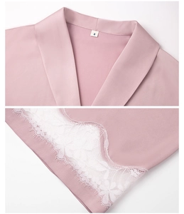 Detail of pink satin sleepwear showing notched collar and white floral eyelash lace hem