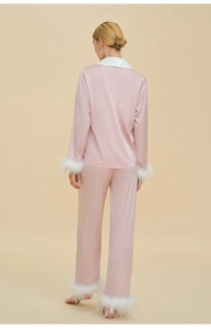 Detailed back view of pink satin pajamas with white feather trim on cuffs and pants