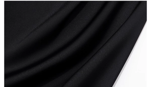 Close-up detail of smooth black pajama fabric with elegant drape and matte texture