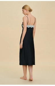 Dettaglio della camicia da notte in raso nero con pizzo bianco e spalline sottili
