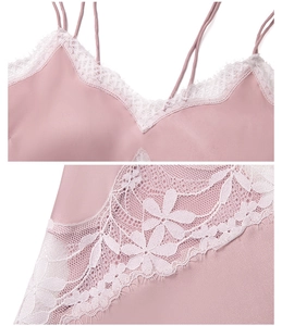 Détail d'une nuisette en satin rose avec col en V et délicates finitions en dentelle blanche