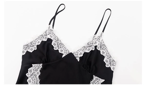 Dettaglio della camicia da notte in raso nero con raffinato pizzo floreale bianco