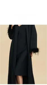 Detail display of black satin robe featuring luxurious faux feather trim on sleeves