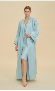 Detailed view of light blue satin pajama set featuring luxurious feather-trimmed cuffs