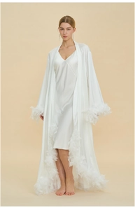 Detailed view of luxury white satin robe with feather trim cuffs and sweeping hemline