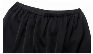 Détail de la taille élastique du pantalon de détente noir avec texture satinée