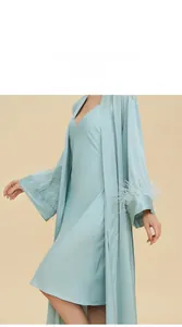 Detail of light blue satin robe with luxury ostrich feather trim on the sleeve cuffs