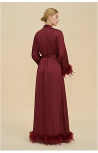 Detail view of wine red luxury satin robe with plush feather trim on sleeves and hemline