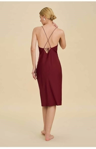 Detail of burgundy satin slip dress showing the backless design with cross straps
