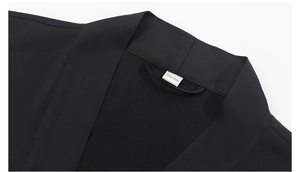 Close-up of the black pajama robe neckline featuring a white One Size woven label