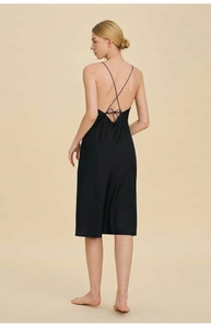 Detailed back view of a black satin slip dress with crisscross straps and a bow tie