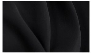 Close-up of the smooth black textile fabric texture with elegant folds and drape