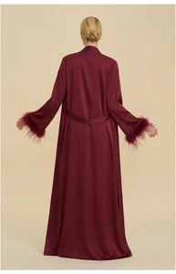 Detail of burgundy satin robe with luxury feather cuffs and matching waist tie belt