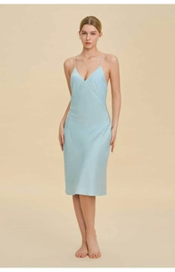 Detail of light blue silk slip dress featuring a deep V-neck and delicate straps