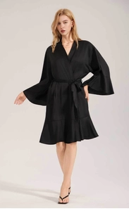 Detail of elegant black matte satin robe featuring wide flare sleeves and ruffled hemline