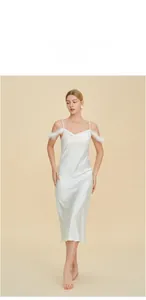 Détail de la robe nuisette en satin blanc avec garniture de plumes luxueuse sur les bretelles