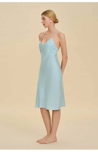 Detail view of a light blue silk v-neck slip dress with backless design and glossy fabric