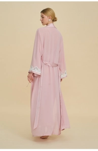 Detail of pink satin robe with delicate white lace trim on sleeves and waist belt
